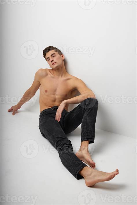 Handsome Man In Black Trousers Sits On The Floor Naked Torso Studio