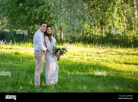 Young Wedding Couple Freshly Wed Groom And Bride Posing Outdoors On
