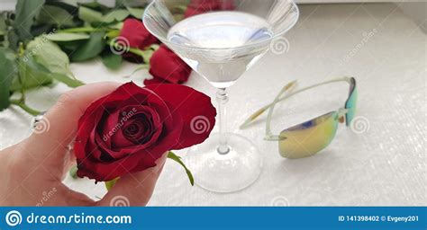 One Red Rose In Female Fingers Against Wide Vine Glass