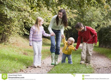 Mother And Children Walking Along Woodland Path Stock