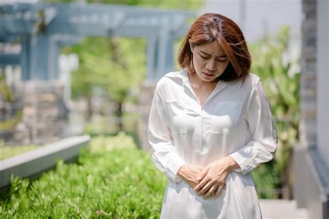 Premium Photo An Asian Woman Is Touching Her Stomach Due To Suffering From Stomach Aches And