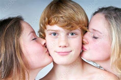 Zwei Mädchen küssen Jungen auf Backe Stockfotos und lizenzfreie