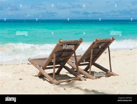 Tropical Beach With Two Beach Chairs Facing The Blue Sea Stock Photo