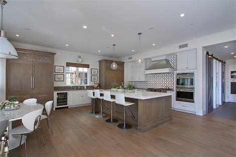 This setting matches with rooms having one side facing the exterior, with a large window with thin wooden frame, painted in white. White Kitchen with Distressed Brown Island - Contemporary - Kitchen