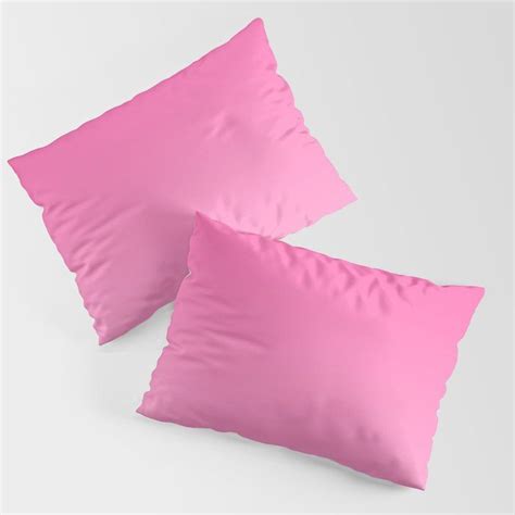 Two Pink Pillows Sitting Next To Each Other