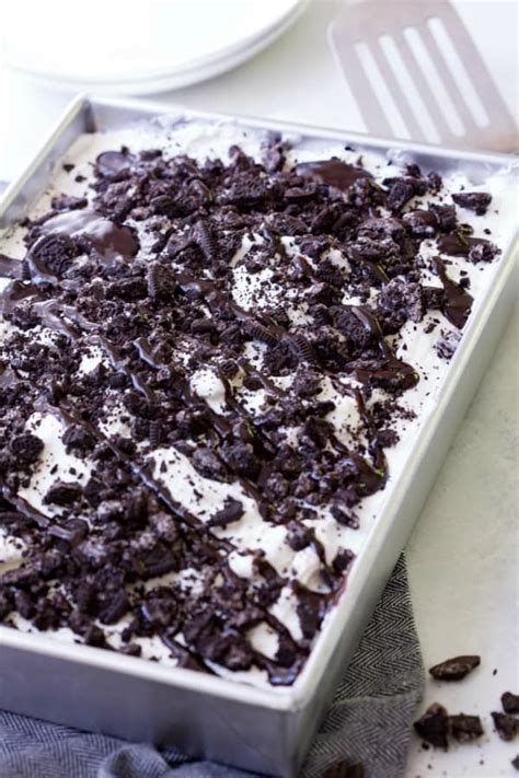 A moist chocolate cake recipe full of oreo icing and crushed up oreos. Oreo Poke Cake-Easy Dessert Recipe-Real Housemoms