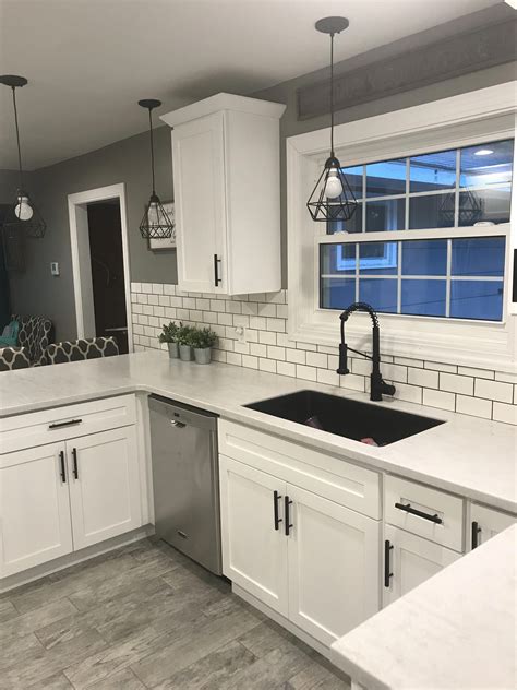 white shaker cabinets with solid surface countertops and flat black handles stainlesssteelsink