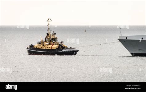 A Tugboat Assists The Sas Amatola From The Simons Town Naval Base On