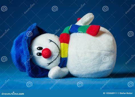 A Cute Little Soft Snowman With A Blue Hat And A Colorful Scarf Stock