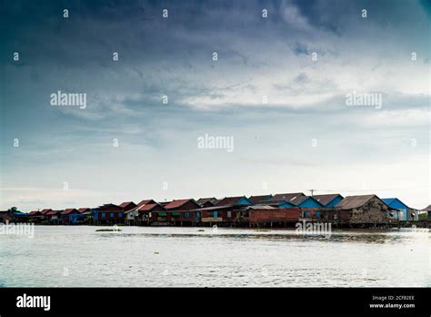 View Of Small Remote Village With Poor Houses Above Water Under Cloudy