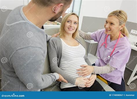 Happy Pregnant Woman And Husband In Hospital With Doctor Stock Image