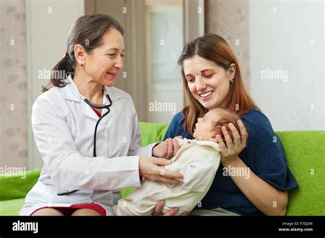 Friendly Mature Childrens Doctor Examining Newborn Baby Stock Photo