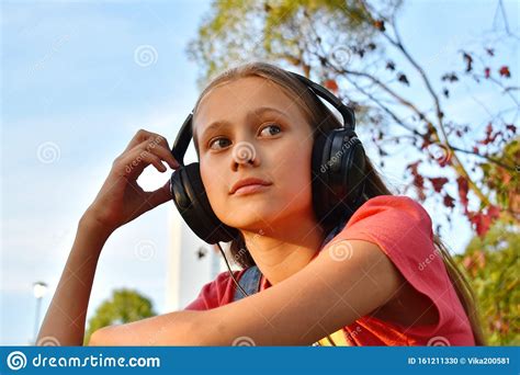 Thoughtful Teenager Girl In Headphones Listening To Music Outsite Stock