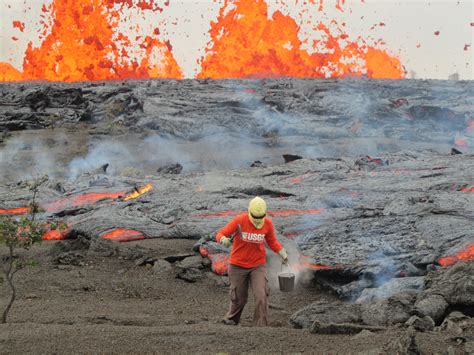 Geologist collecting sample of molten lava from 2011 Kamoamoa erupt...