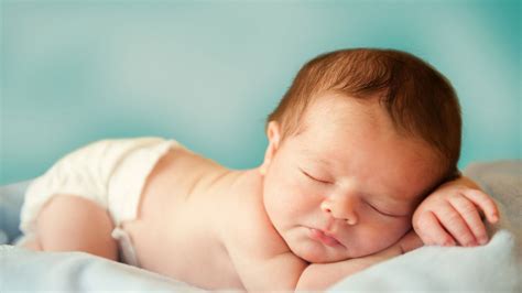 Cute Baby Is Sleeping On White Bed In Blur Blue Background
