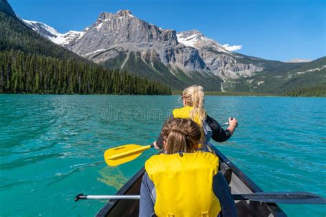 Two Women Paddle A Canoe On Emerald Lake In The Summer In Yoho