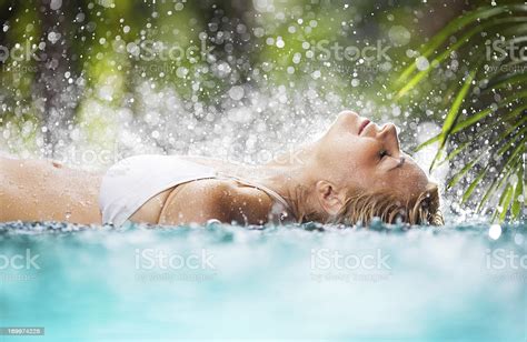 Beautiful Woman Lying In The Tropical Pool Stock Photo