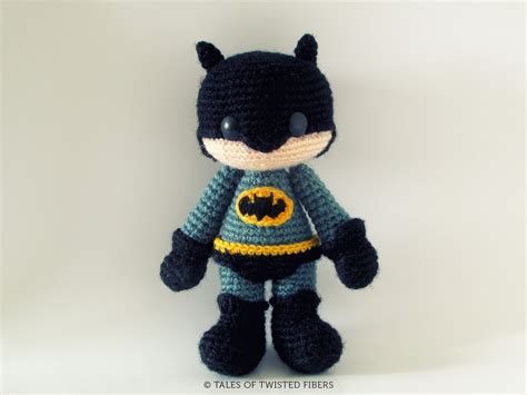 A Crocheted Batman Doll Is Posed On A White Background With The Bat Symbol