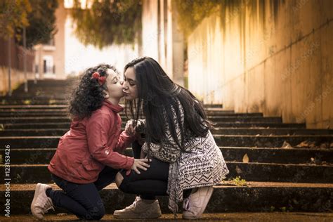 Niña Y Adolescente Hermanas Felices Dándose Un Beso En Las Escaleras