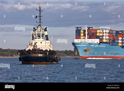 Tug Boats With Container Ship Ready To Dock At Southampton Stock Photo