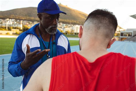 African American Male Coach Instructing Caucasian Male Athlete With