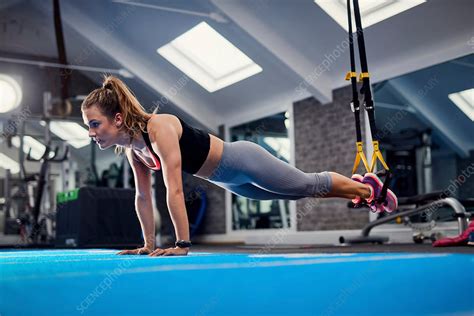 Young Woman Doing Push Ups Using Exercise Handles In Gym Stock Image