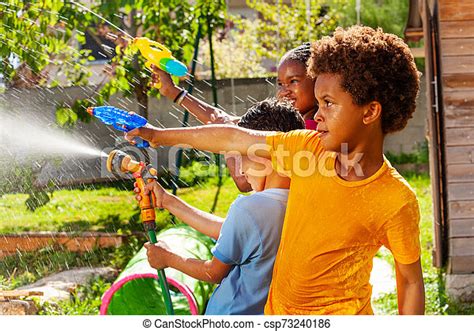 Boy With Group Of Children Shoot Water Pistol Little Boy Among Group