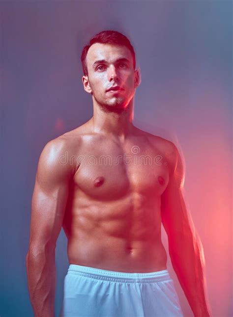 Athletic Male With Naked Muscular Torso Posing In Colorful Light