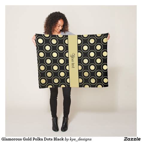 A Woman Holding Up A Black And Gold Polka Dot Blanket