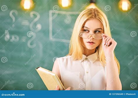 attractive lecturer concept woman with book starts lesson gazes at audience while taking off