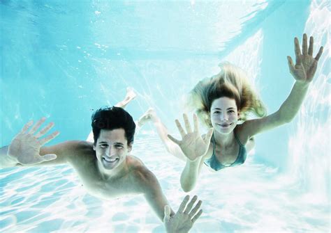 Portrait Of Smiling Couple Underwater In Pool Stock Photo
