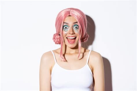 Крупным планом удивленная счастливая девушка в розовом парике улыбающаяся и возбужденная глядя