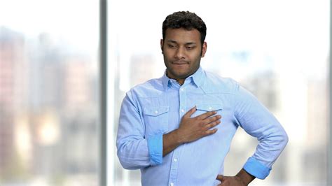 Young Indian man having chest pain. Unhappy middle-aged man suffering 