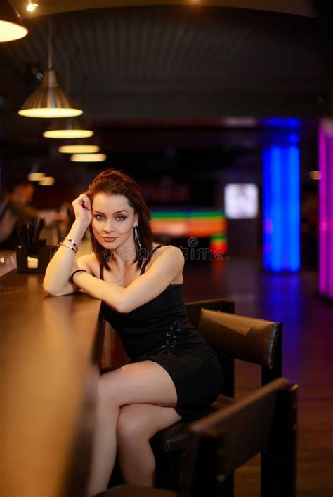 Beautiful Brunette Woman In Evening Dress Posing Near Bar Alone Stock