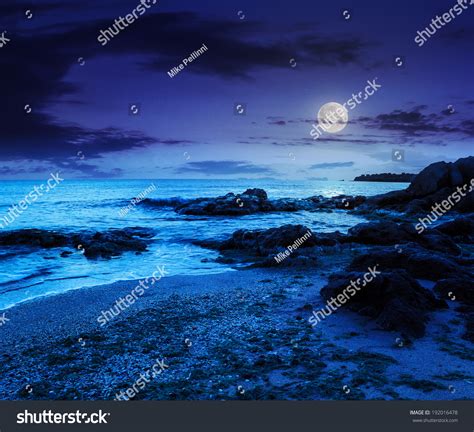 Calm Sea With Some Wave Attacks The Sandy Beach With Boulders And