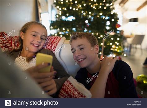 Brother And Sister Texting Near Christmas Tree Stock Photo Alamy