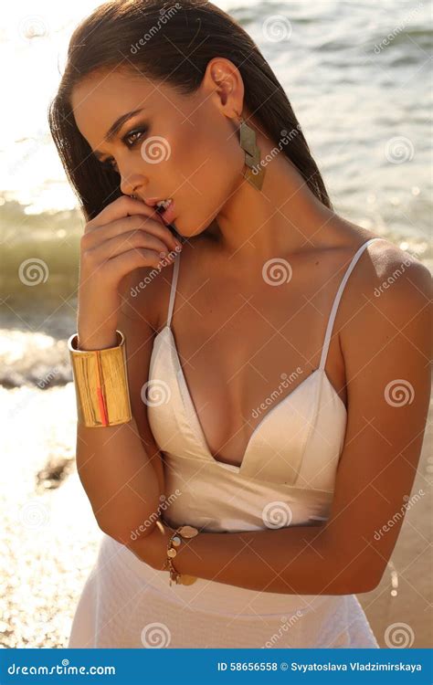 Girl With Dark Hair And Tanned Skin Posing On Beach Stock Photo Image