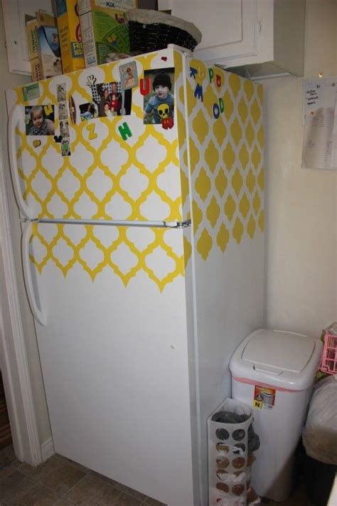 A White Refrigerator Covered In Magnets Next To A Trash Can