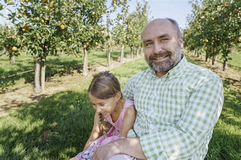 Father And Daughter Enjoying Weekend Art Apple Orchard Stock Photo