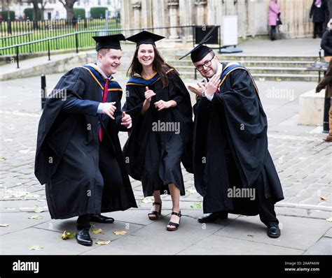 A Group Of Happy York St John University Graduates Wearing Gowns And