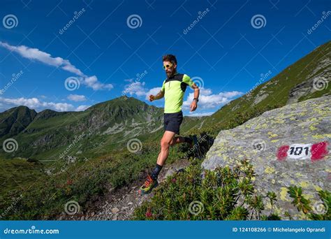 Male Athlete Practicing Mountain Running On A Trail Downhill Stock