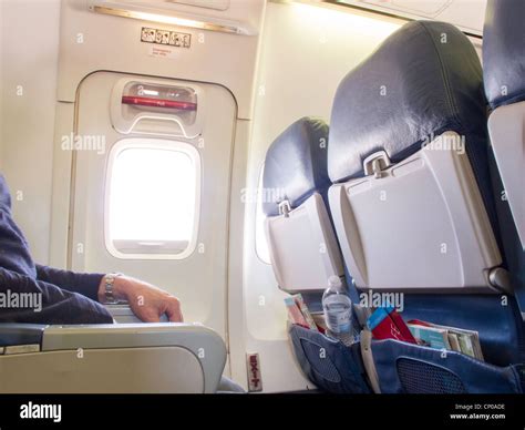 Male Passenger Sits In Emergency Exit Row On Airplane Stock Photo Alamy