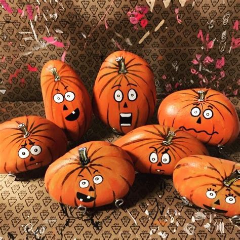 Five Pumpkins With Faces Painted On Them