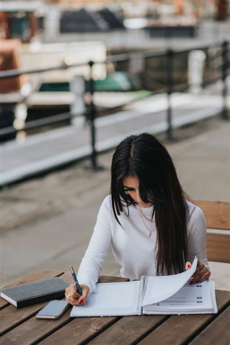 Crop Office Employee Taking Notes In Notebook At Table · Free Stock Photo