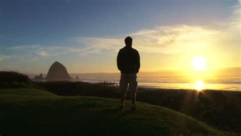 Man At Pacific Ocean Near Cannon Beach Looks Out To Sea As