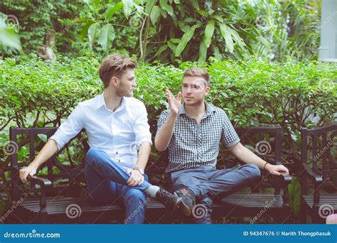 Two Friends Men Talking Sitting In A Garden Stock Photo Image Of