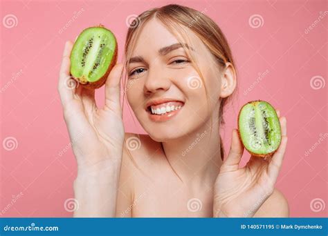 Attractive Girl Holding Kiwi Slices On A Pink Background Natural