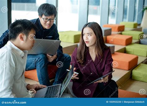 Asian Colleagues Sharing Ideas In Office Meeting Room Stock Photo
