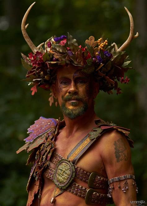 A Man With Horns And Flowers On His Head Is Wearing A Costume Made Of