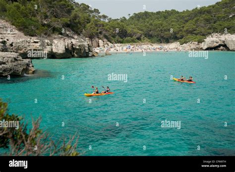 Tourists Canoe In The Waters Of Cala Mitjana In Menorca Spain Stock